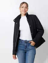 Campera acolchada negra con diseño capitoné de rombos. Posee cuello alto abotonado y cierre frontal oculto con botones a presión dorados. Incluye bolsillos delanteros con solapa y botones a presión dorados.