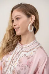 Aros argollas de diseño rústico, forrados en tela beige con textura.