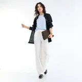 Pantalón de lino blanco de corte ancho, con cintura elástica ajustable mediante cordón y bolsillos laterales.