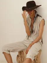 Mono color beige de lino, con cuello mao, mangas cortas con dobladillo y cierre frontal con botones.