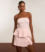 Blusa peplum de viscosa color rosa, con escote strapless, frunces en el busto y volado en la cintura.