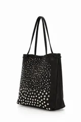 Cartera tote negra con asas finas y tachas plateadas de diferentes tamaños en el frente, creando un efecto degradado.