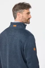 Campera de felpa gris melange, con interior de polar, cuello alto, cierre frontal completo y bolsillos laterales. Presenta detalles de apliques en cuero sintético en el pecho y la manga.