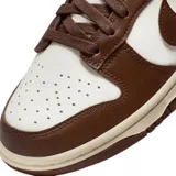 Championes Nike Dunk Low con diseño bicolor en tonos marrón y blanco. Presentan una silueta clásica de perfil bajo con paneles de cuero, puntera perforada para mayor ventilación y suela de goma resistente.