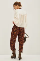 Pantalon de corte recto con estampado tipo ikat en tonos marrón y ocre, con cintura alta y bolsillos laterales.