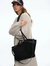 Kimono largo de tejido de punto en color beige, con diseño de sisa caída y mangas abullonadas que aportan volumen. Presenta una silueta relajada y abierta al frente.