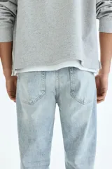Jean de cinco bolsillos en denim de algodón con lavado claro y leve efecto desteñido. Modelo de cintura clásica, con cierre frontal y corte recto de pierna holgada.
