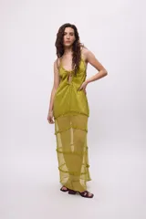 Vestido midi de tela semitransparente con acabado brillante en color verde esmeralda. Presenta un diseño con volados en los recortes, escote con cordón ajustable y breteles finos.