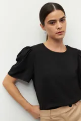 Top color verde claro, de mangas cortas abullonadas y cuello redondo.