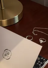 Conjunto de joyería de tres piezas en plata 925 y zirconias, compuesto por una pulsera con cadena y zirconias colgantes, un anillo medio sin fin con zirconias y un anillo solitario con zirconias en corte gota y pavé lateral.