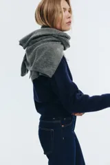 Buzo de punto suave color azul marino, con cuello redondo y abertura frontal con botones dorados. Presenta hombros caídos y puños y bajo en punto acanalado.