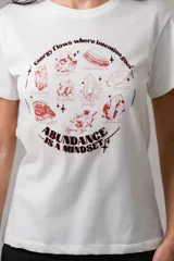 Remera de algodón blanca con cuello redondo y mangas cortas. Presenta un estampado frontal en color bordó con ilustraciones de cristales y frases motivacionales.