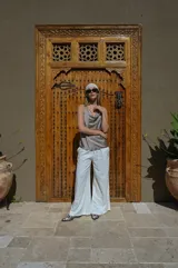 Musculosa de poliéster color blanco, con escote drapeado y breteles finos.