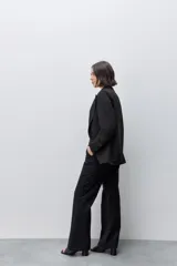 Pantalón de vestir tiro alto wide leg negro, con silueta amplia, bolsillos laterales funcionales y bolsillos traseros de vivo, confeccionado en algodón.