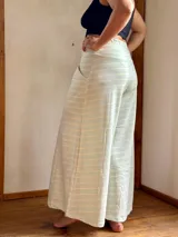 Pantalón palazzo de tiro alto con estampado de rayas horizontales color crema y celeste. Confeccionado en rústico de algodón, con bolsillos laterales, elástico en la espalda y faja ancha en la cintura.