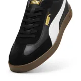 Championes Puma Club II Era, color negro con franja lateral blanca y suela de goma color caramelo. Presenta detalles en dorado en el logo lateral y lengüeta.