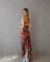 Vestido largo de corte al cuerpo con escote profundo en V y espalda descubierta. Confeccionado en tela fluida con estampado artístico en tonos celeste, terracota y azul.