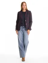 Blazer sastrero entallado con estampado de cuadros en tonos azul y bordó. Presenta cuello con solapa clásica, cierre frontal con botón metálico plateado, bolsillos ojal en el frente y bolsillo en el pecho. Cuenta con pinzas frontales y costuras posteriores para definir la cintura, además de una abertura central en el ruedo trasero.