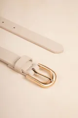 Cinturón color beige de cuero sintético con hebilla dorada texturizada.
