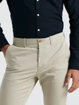 Pantalón chino de hombre color beige, con bolsillos delanteros diagonales, cierre y botón en la cintura. Logo bordado a tono. Confeccionado en 98% algodón y 2% elastano.