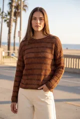 Sweater texturado de punto en tonos marrones con sutiles destellos metalizados, cuello redondo y mangas largas.