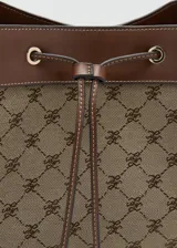 Bolso tipo bucket de poliéster y poliuretano, con diseño estampado geométrico en tonos marrón y beige, detalles en cuero sintético marrón, cierre de cordón ajustable y asa de hombro.