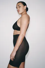 Shorts tipo ciclista de tiro alto con cintura elástica, confeccionado en poliamida con paneles laterales y frontales de tejido mesh. Presenta un diseño con efecto reductor que estiliza la figura.