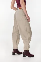 Pantalón jean azul marino, de corte balloon o slouchy, con tiro alto, bolsillos delanteros y traseros, y costuras curvadas en las piernas.