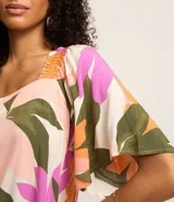Blusa de mangas cortas con escote cuadrado y estampado floral en tonos rosa, naranja, verde y blanco.