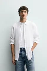 Camisa blanca de lino de corte regular fit, con cuello abotonado, manga larga y cierre frontal de botones.