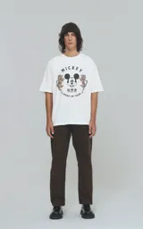 Remera de manga corta con cuello redondo y calce oversize, confeccionada en algodón premium. Presenta un estampado frontal con la cara de Mickey Mouse rodeada de dos tigres y texto alusivo.