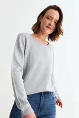 Sweater de punto fino en color gris con acabado metalizado, de corte recto, cuello redondo y manga larga.