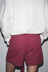 Shorts color rosa viejo, de tiro medio y corte holgado, con cintura elástica y cinturón de lazo ajustable.