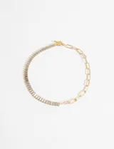 Collar dorado con cadena de eslabones rectangulares y tira de strass plateados. Cierre con barra en forma de T.