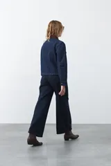 Jean de corte amplio y tiro medio, con diseño de costuras verticales frontales y bolsillos laterales tipo parche. Presenta un acabado en tono azul clásico.