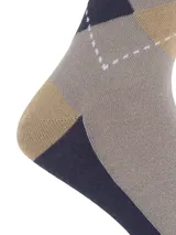 Medias de largo medio con diseño de rombos en tonos gris, beige y azul marino. Incluye el logo bordado de la marca en uno de los rombos.