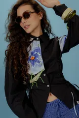 Camisa verde con lunares violetas, cuello clásico, mangas abullonadas y lazos laterales para ajustar.