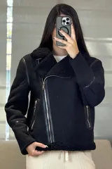 Campera tipo gamulán de color crema con interior y cuello de corderito sintético. Presenta cierre frontal cruzado, bolsillos laterales con cierre y detalles de costuras en contraste color marrón oscuro.