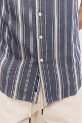 Camisa de manga corta color azul con diseño a rayas verticales, cuello clásico y cierre frontal de botones.