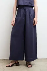 Pantalón blanco de lino, de corte palazzo, tiro alto y pierna ancha.