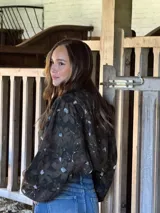 Camisa de lino con estampado orgánico en tonos oscuros, de silueta relajada, mangas amplias y detalle de nudo frontal.