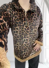 Buzo marrón con estampado animal print y cuello polo con cierre de cremallera.