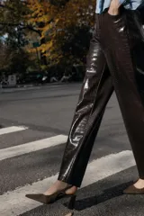 Zapato destalonado de gamuza color marrón con tacón en bloque de altura media y punta fina. Presenta una tira trasera con elástico para mayor ajuste.