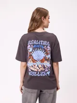 Remera de corte holgado color gris oscuro, con estampa gráfica en la espalda que incluye montañas, un sol y el texto 'Realities Collide'.
