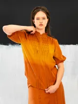 Blusa azul de algodón tipo seda, teñida a mano con técnica tie dye. Tiene corte recto, mangas cortas abullonadas con elástico y cierre invisible en el escote delantero.