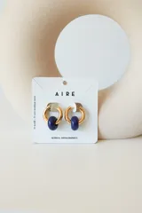 Aros dorados con dije circular de piedra natural negra.