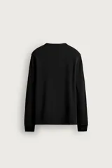 Camiseta relaxed fit de manga larga y cuello redondo, confeccionada en tejido de algodón con estructura waffle en color negro.