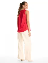 Blusa sin mangas de satén labrado con diseño de textura sutil. Presenta cuello redondo a la base con detalle de frunces tipo punto smock.