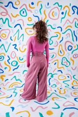 Pantalón sastrero de corte amplio y tiro alto, color rojo vibrante. Presenta pinzas en la cintura, cierre frontal con botón a la vista y diseño de pierna ancha.