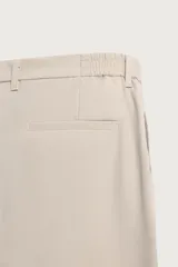 Pantalón regular fit color negro de corte recto, con cintura elástica en los laterales, trabillas, bolsillos frontales y cierre con botón y cremallera.
